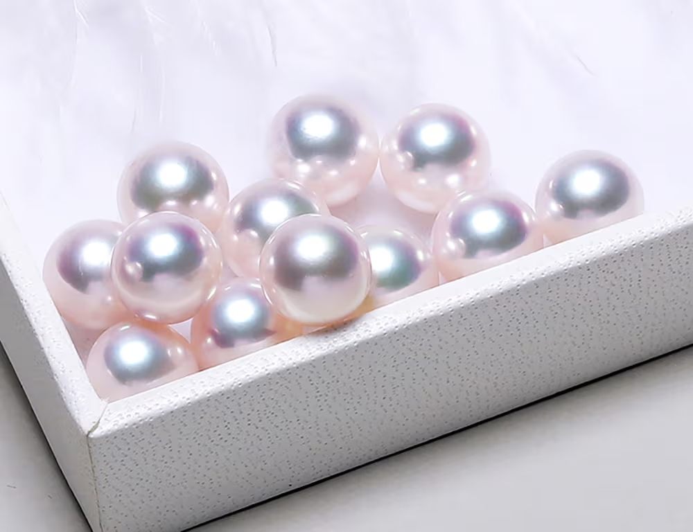 نمای نزدیک از چند مروارید گرد با سطح بسیار صاف و یکدست؛ بدون خط و نقطهٔ قابلمشاهده و با بازتاب یکنواخت نور برای نمایش «کیفیت سطح مروارید (Surface Quality)